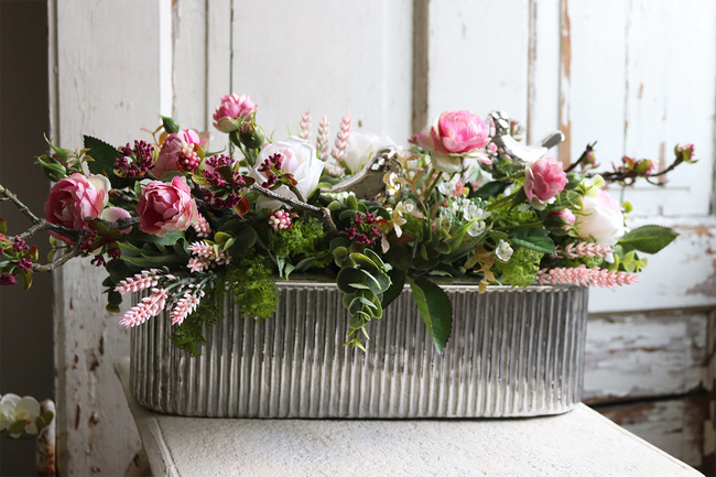 kompozycja kwiatowa w srebrnej donicy, Pinkelia, wym.25x60cm