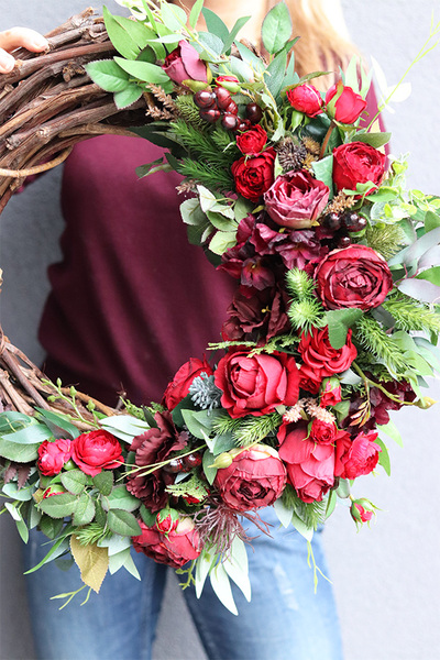Bordonna, asymetryczny wianek z czerwonym kwiatami